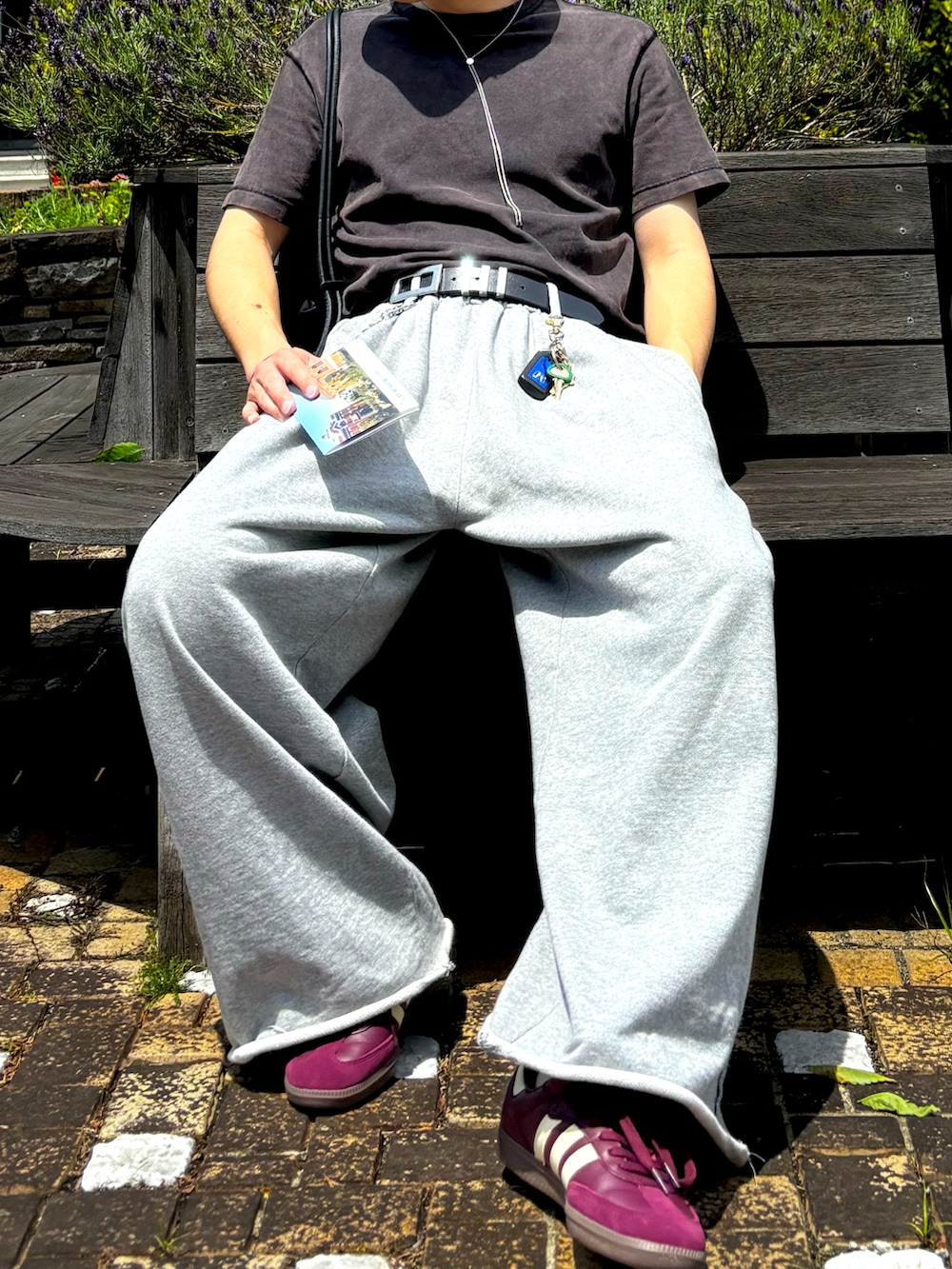 グレー系のスウェットパンツ、レッド系のスニーカー、シルバー系のネックレスを着用したメンズの夏コーディネートの2枚目の写真