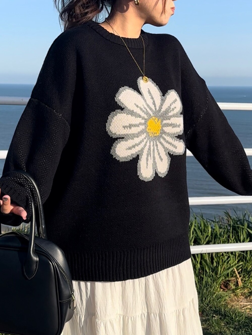 ブラック系のニット/セーター、ゴールド系のネックレスを着用したレディースの秋コーディネートの3枚目の写真