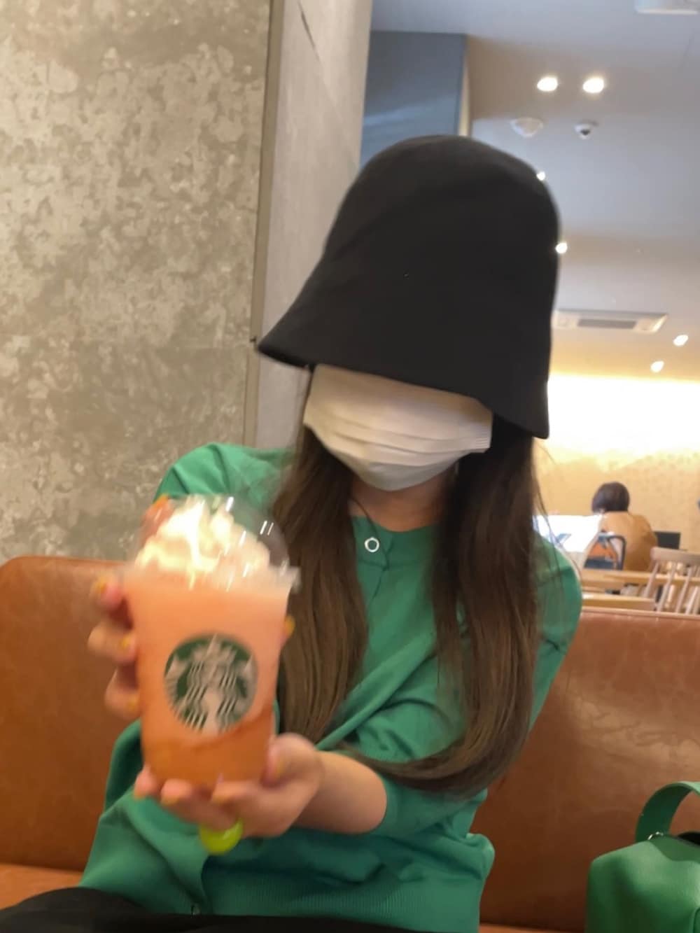 グリーン系のカーディガン/ボレロ、ブラック系のハットを着用したレディースの夏コーディネートの2枚目の写真