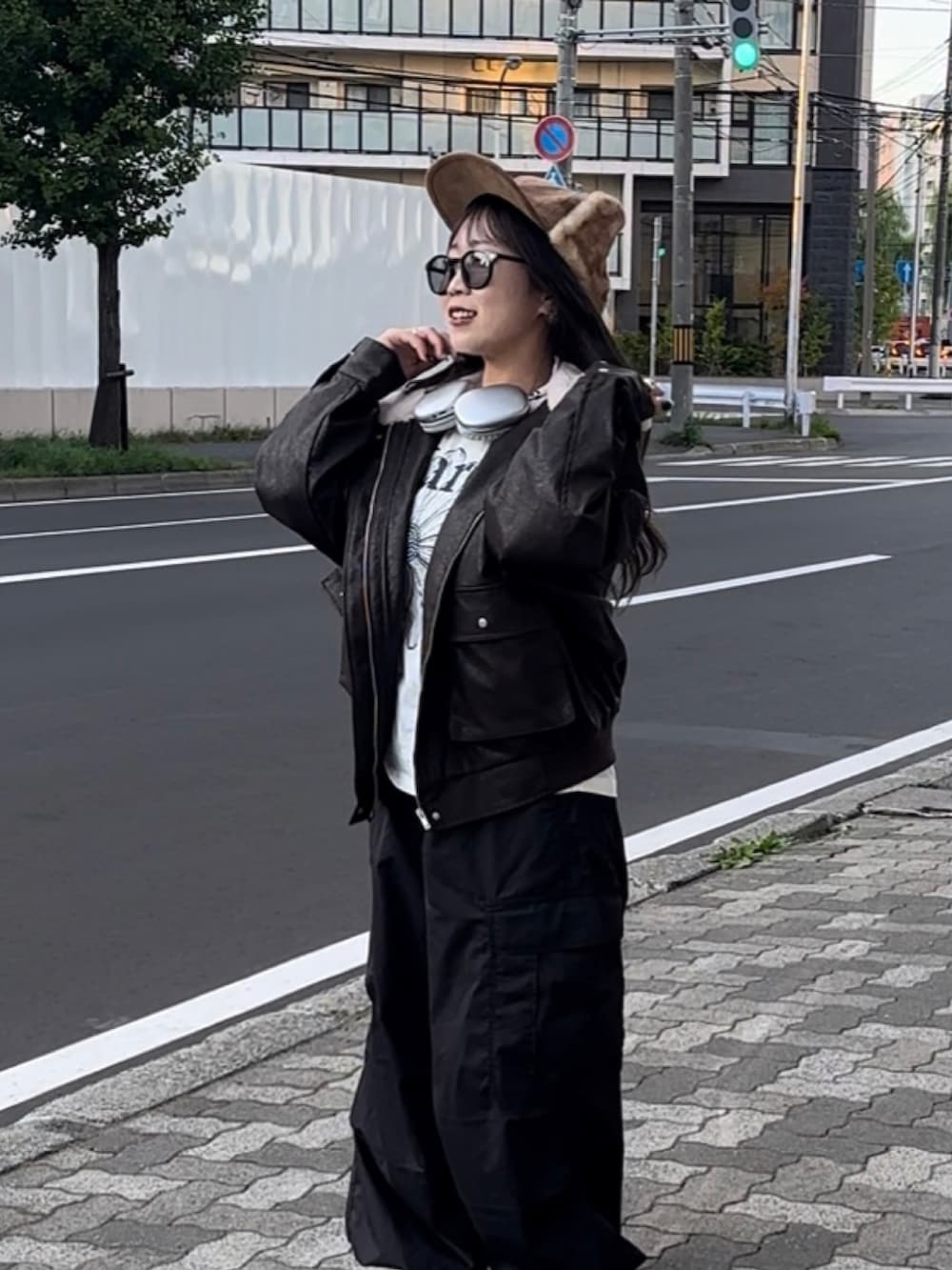 ブラウン系のブルゾン、ホワイト系のTシャツ/カットソー、ブラック系のカーゴパンツを着用したレディースの秋コーディネートの3枚目の写真