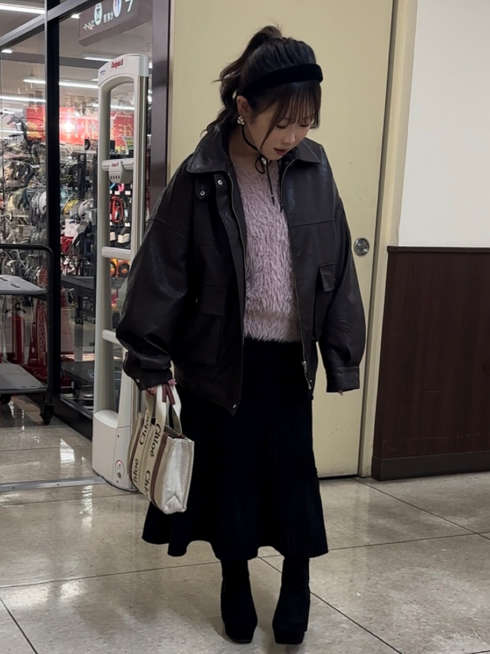 ブラウン系のブルゾン、ピンク系のニット/セーター、ベージュ系のハンドバッグを着用したレディースの冬コーディネートの3枚目の写真