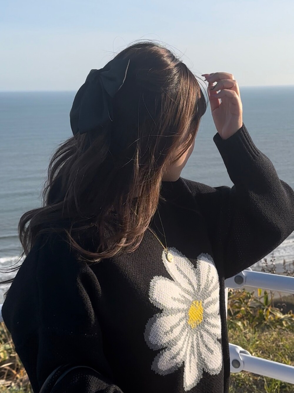 ブラック系のニット/セーター、ゴールド系のネックレスを着用したレディースの秋コーディネートの2枚目の写真