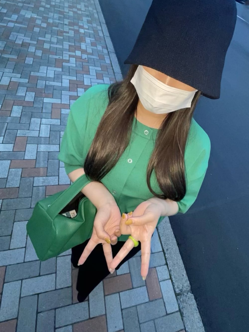 グリーン系のカーディガン/ボレロ、ブラック系のハットを着用したレディースの夏コーディネートの3枚目の写真