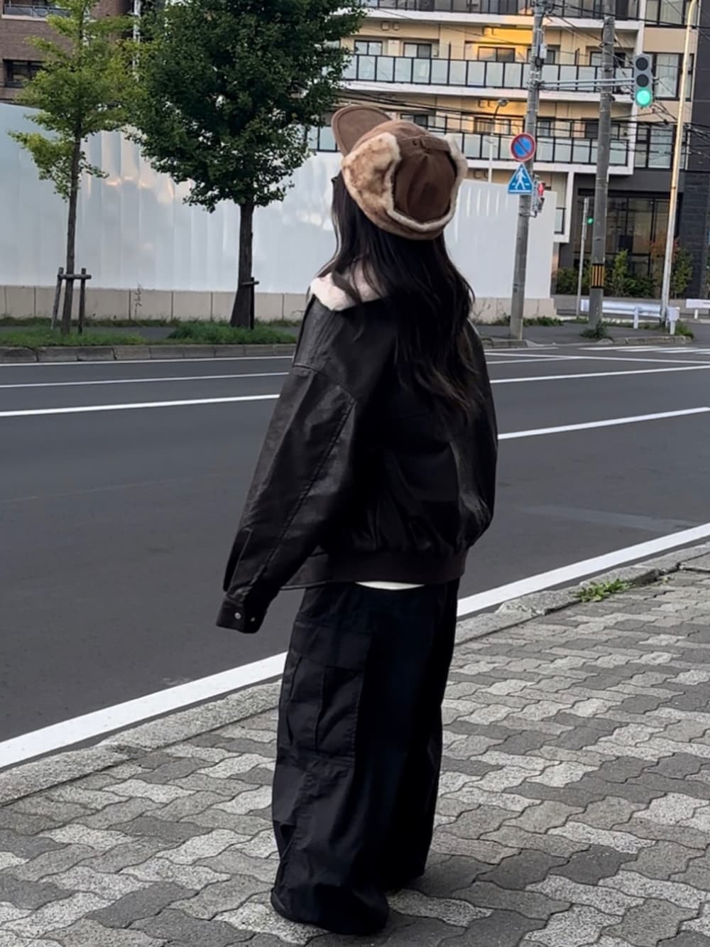 ブラウン系のブルゾン、ホワイト系のTシャツ/カットソー、ブラック系のカーゴパンツを着用したレディースの秋コーディネートの2枚目の写真