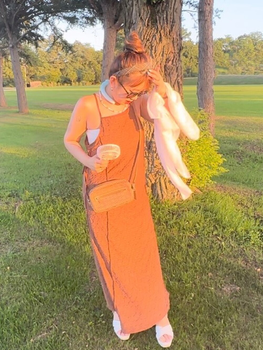 ブラウン系のワンピース、ブラウン系のショルダーバッグ、ブラウン系の腕時計を着用したレディースの夏コーディネートの2枚目の写真