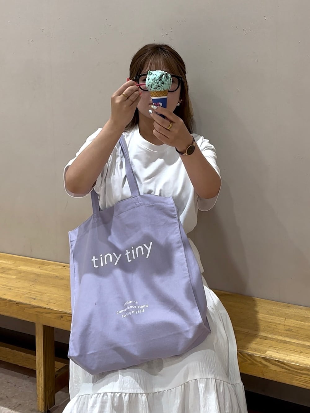 ホワイト系のTシャツ/カットソー、パープル系のトートバッグ、ホワイト系のパンプスを着用したレディースの夏コーディネートの2枚目の写真