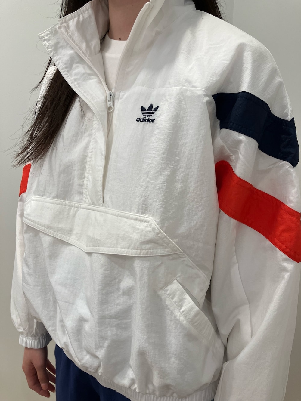 ホワイト系のナイロンジャケット、ブルー系のその他パンツ、ホワイト系のシューズを着用したレディースの春コーディネートの2枚目の写真