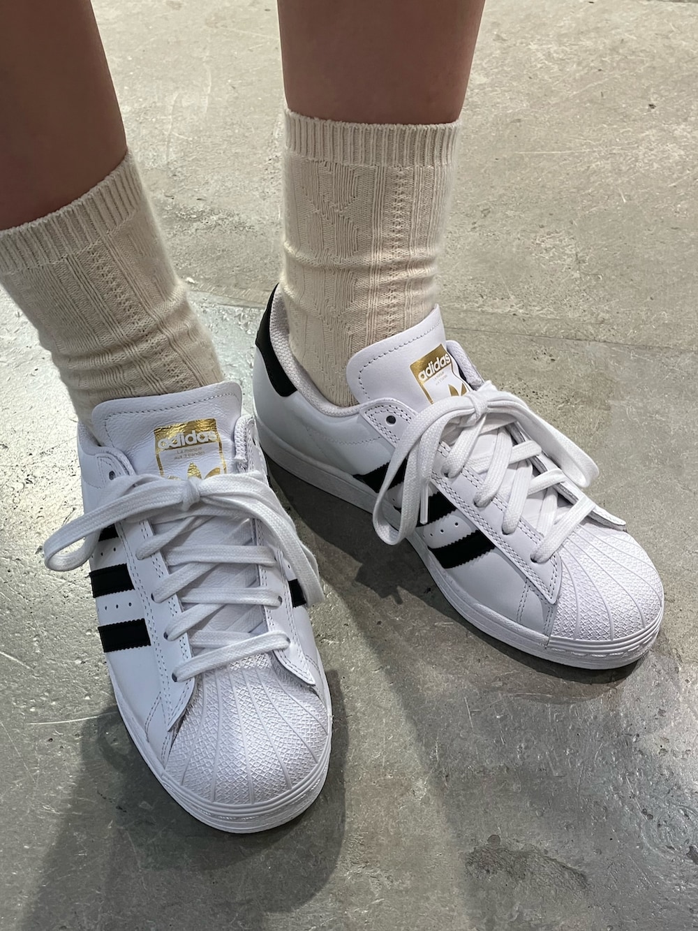 ホワイト系のスニーカー、ブラック系のショルダーバッグ、ブラック系のジャージを着用したレディースの夏コーディネートの3枚目の写真