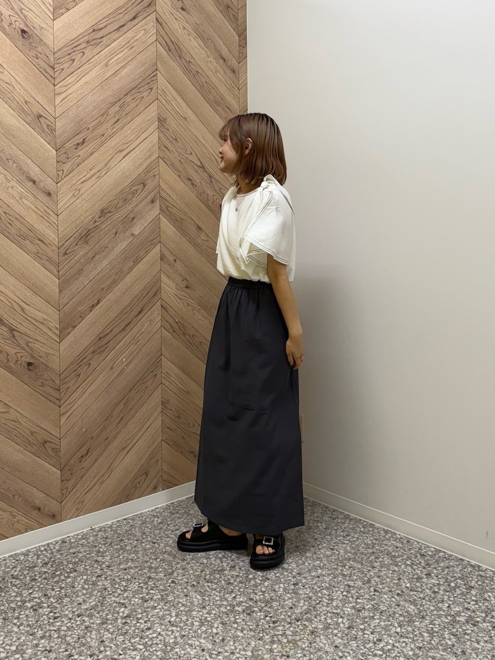 ホワイト系のシャツ/ブラウス、グレー系のワンピース、ブラック系のサンダルを着用したレディースの夏コーディネートの2枚目の写真