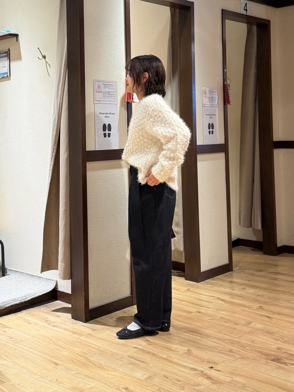 ホワイト系のニット/セーター、ブラック系のデニムパンツ、ブラック系のボストンバッグを着用したレディースの秋コーディネートの2枚目の写真