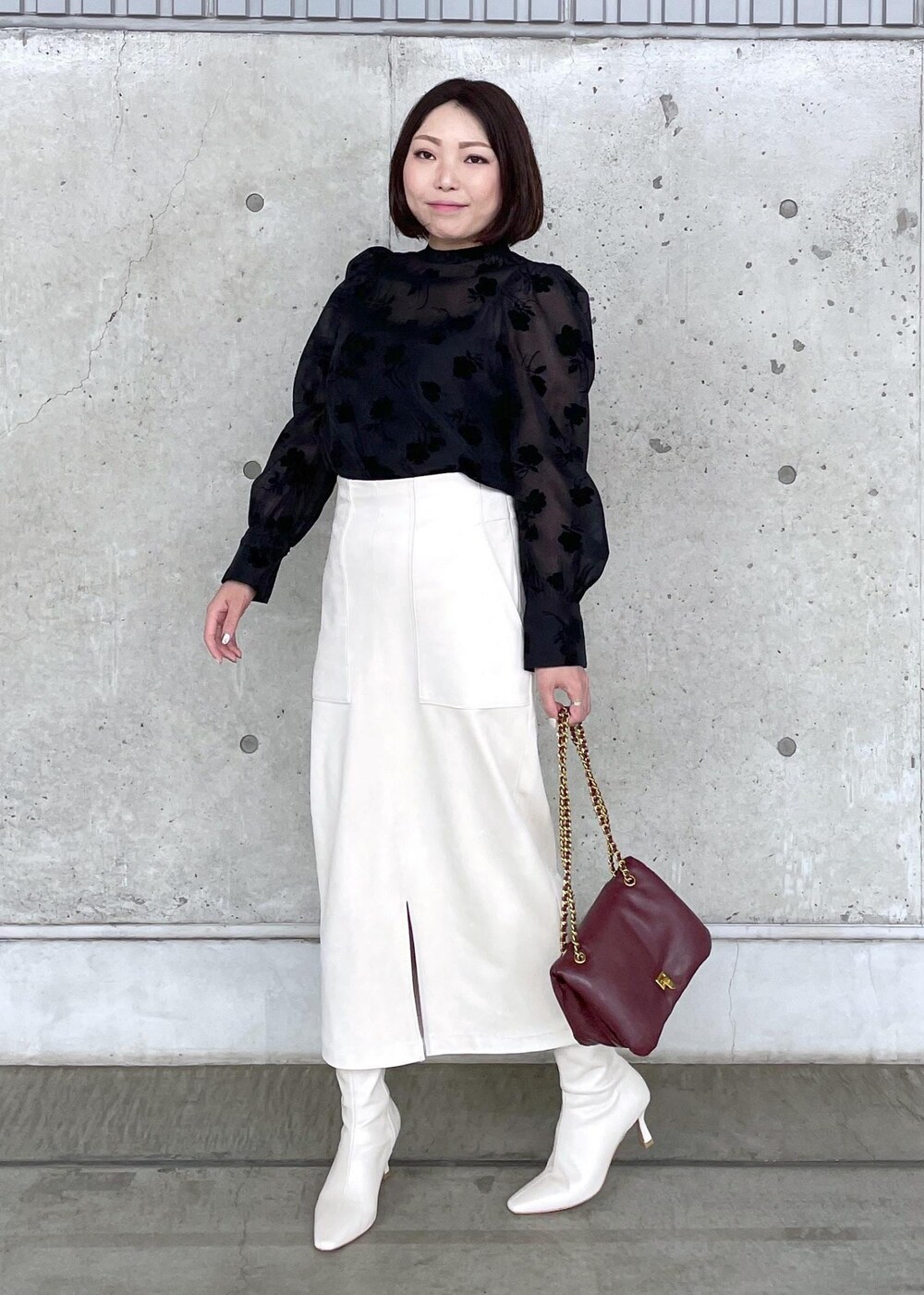 ホワイト系のブーツ、レッド系のハンドバッグ、ホワイト系のスカートを着用したレディースの秋コーディネートの3枚目の写真