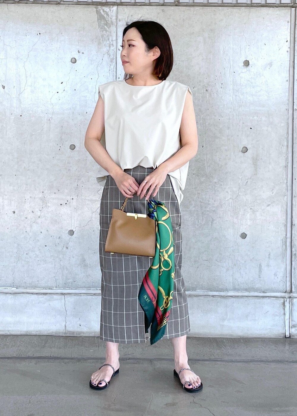 ベージュ系のシャツ/ブラウス、ベージュ系のショルダーバッグ、ブラウン系のスカートを着用したレディースの夏コーディネートの2枚目の写真
