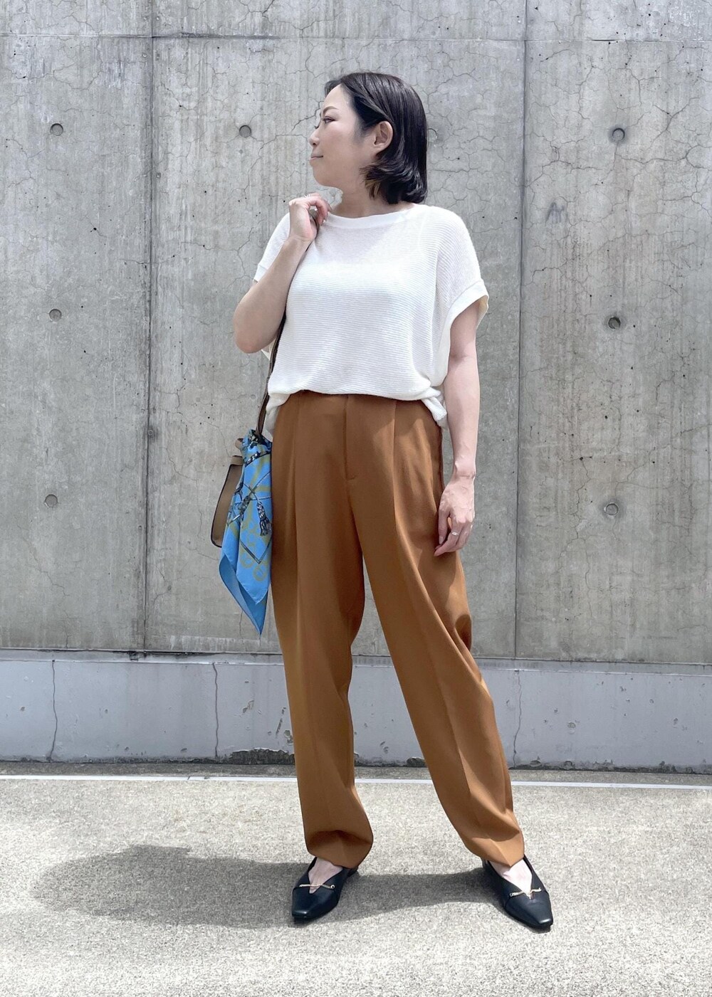 ベージュ系のショルダーバッグ、ブラック系のパンプス、ブラウン系のその他パンツを着用したレディースの夏コーディネートの2枚目の写真