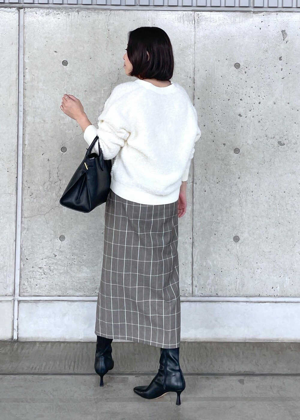 ブラック系のブーツ、ブラック系のトートバッグ、ブラウン系のスカートを着用したレディースの秋コーディネートの5枚目の写真