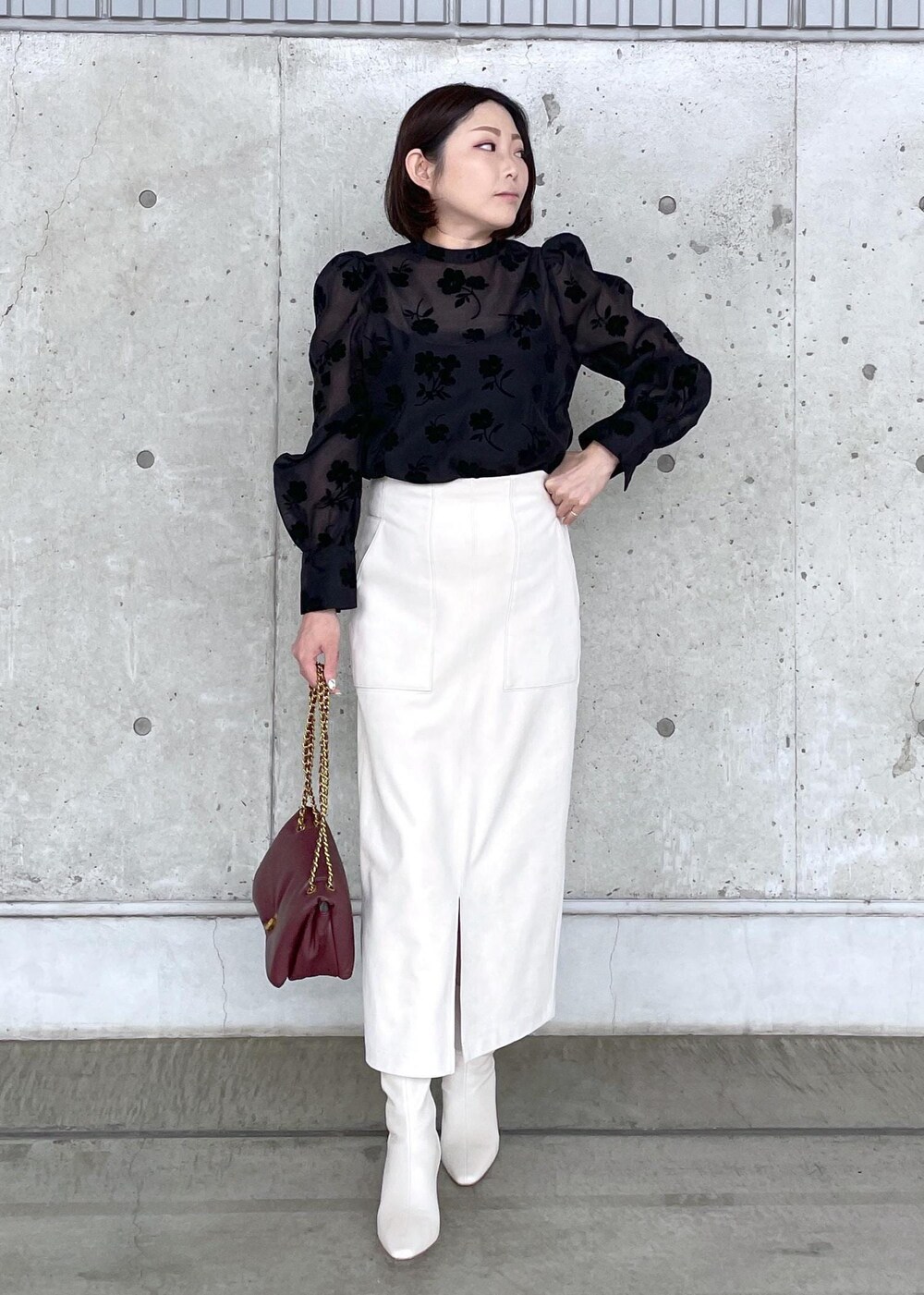 ホワイト系のブーツ、レッド系のハンドバッグ、ホワイト系のスカートを着用したレディースの秋コーディネートの2枚目の写真