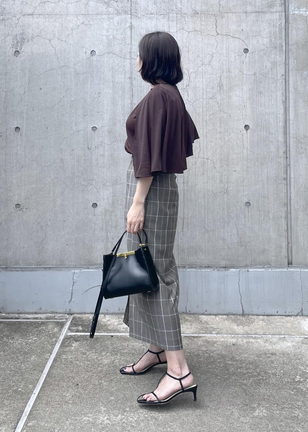 ブラック系のサンダル、ブラック系のショルダーバッグ、ブラウン系のTシャツ/カットソーを着用したレディースの夏コーディネートの3枚目の写真