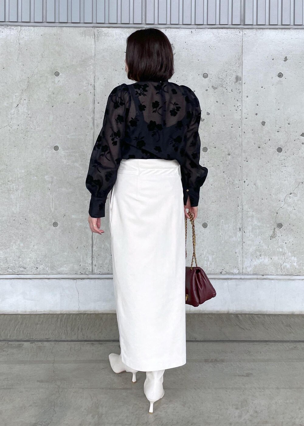 ホワイト系のブーツ、レッド系のハンドバッグ、ホワイト系のスカートを着用したレディースの秋コーディネートの6枚目の写真