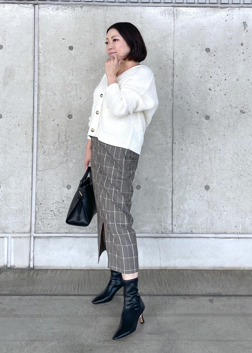 ブラック系のブーツ、ブラック系のトートバッグ、ブラウン系のスカートを着用したレディースの秋コーディネートの3枚目の写真