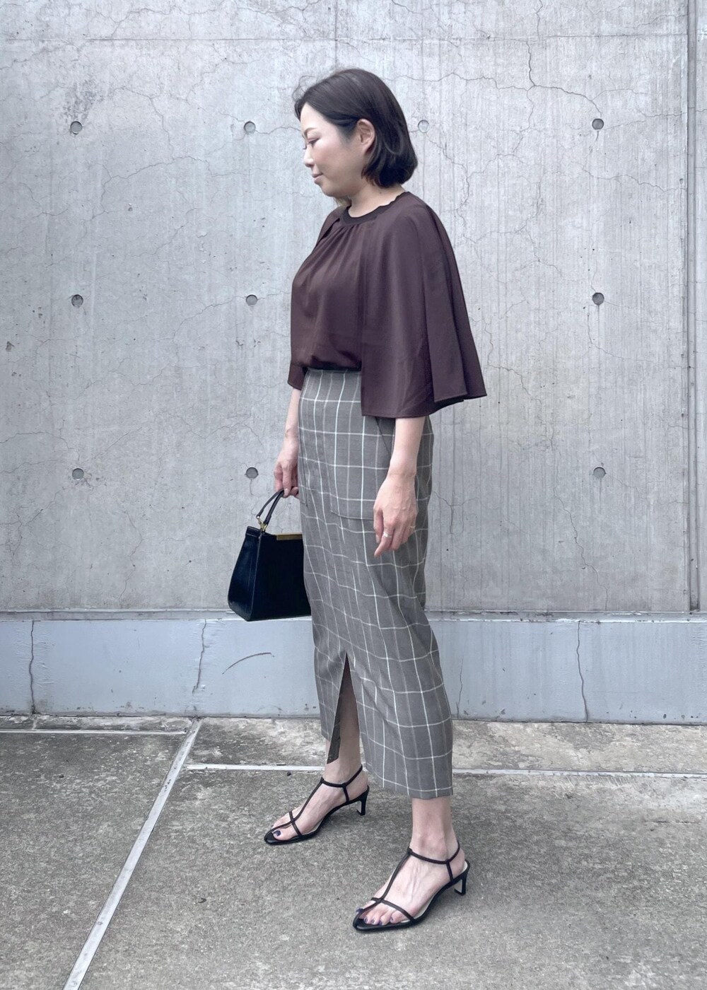 ブラック系のサンダル、ブラック系のショルダーバッグ、ブラウン系のTシャツ/カットソーを着用したレディースの夏コーディネートの4枚目の写真