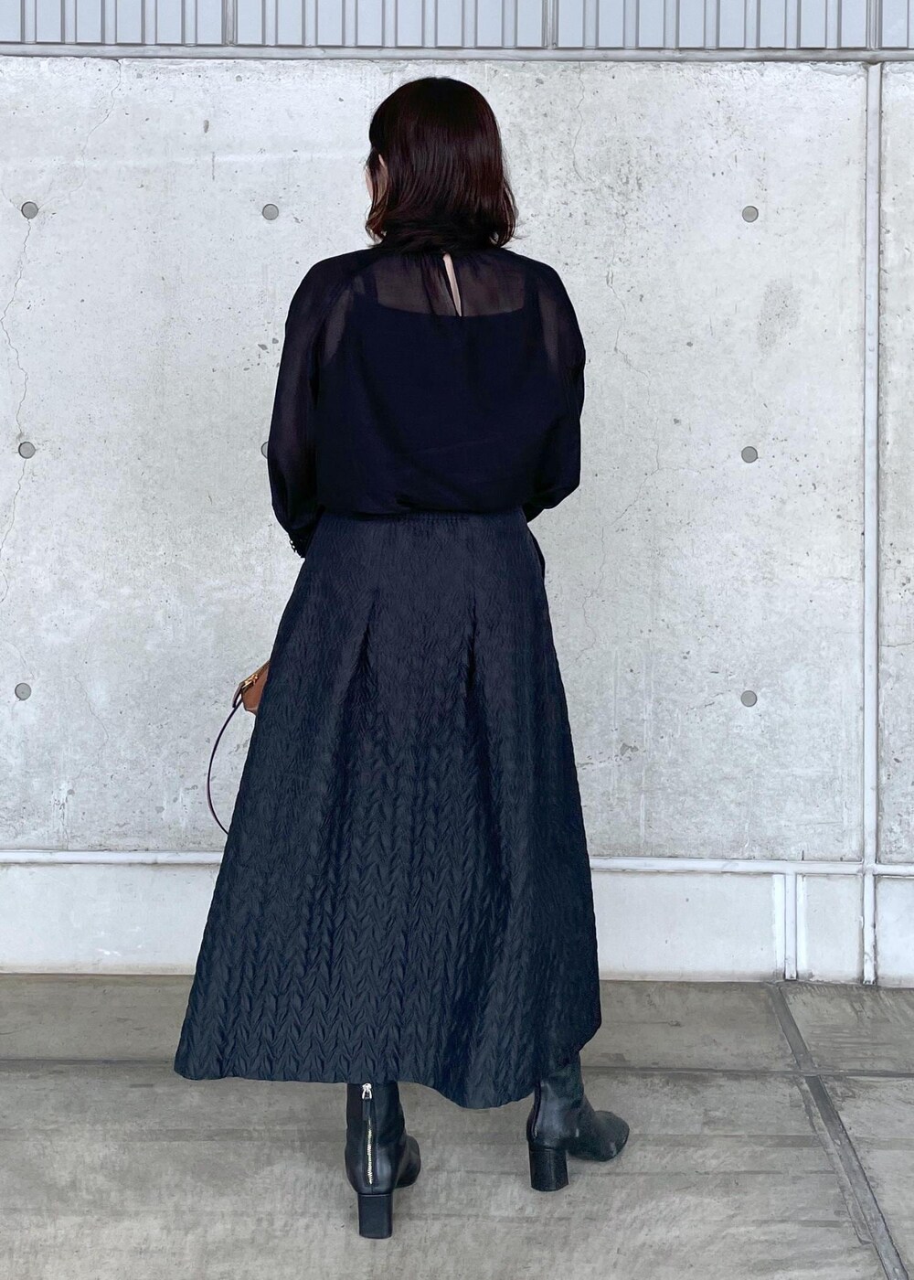 ブラウン系のハンドバッグ、ブラック系のシャツ/ブラウス、ブラック系のスカートを着用したレディースの夏コーディネートの5枚目の写真