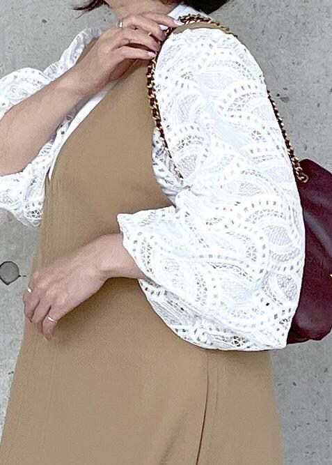 ホワイト系のブーツ、レッド系のハンドバッグ、ベージュ系のジャンパースカートを着用したレディースの秋コーディネートの7枚目の写真