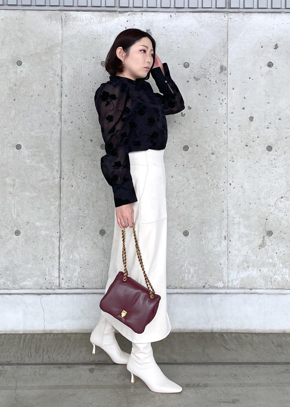 ホワイト系のブーツ、レッド系のハンドバッグ、ホワイト系のスカートを着用したレディースの秋コーディネートの5枚目の写真