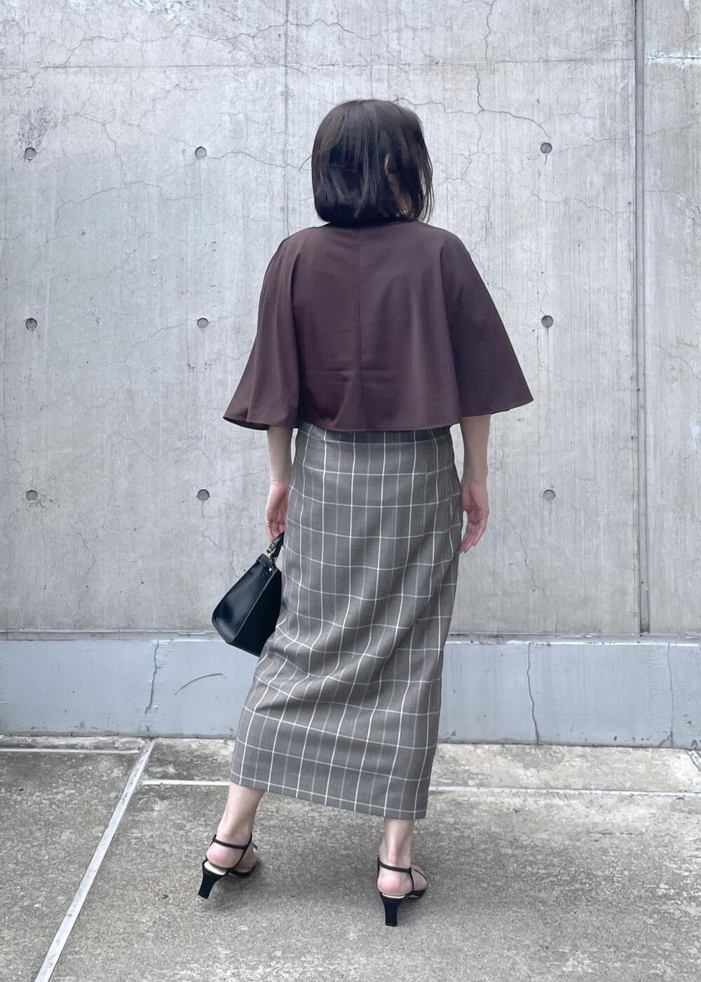 ブラック系のサンダル、ブラック系のショルダーバッグ、ブラウン系のTシャツ/カットソーを着用したレディースの夏コーディネートの5枚目の写真