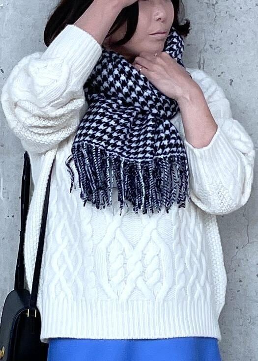 ブラック系のショルダーバッグ、ホワイト系のブーツ、ブルー系のスカートを着用したレディースの秋コーディネートの6枚目の写真