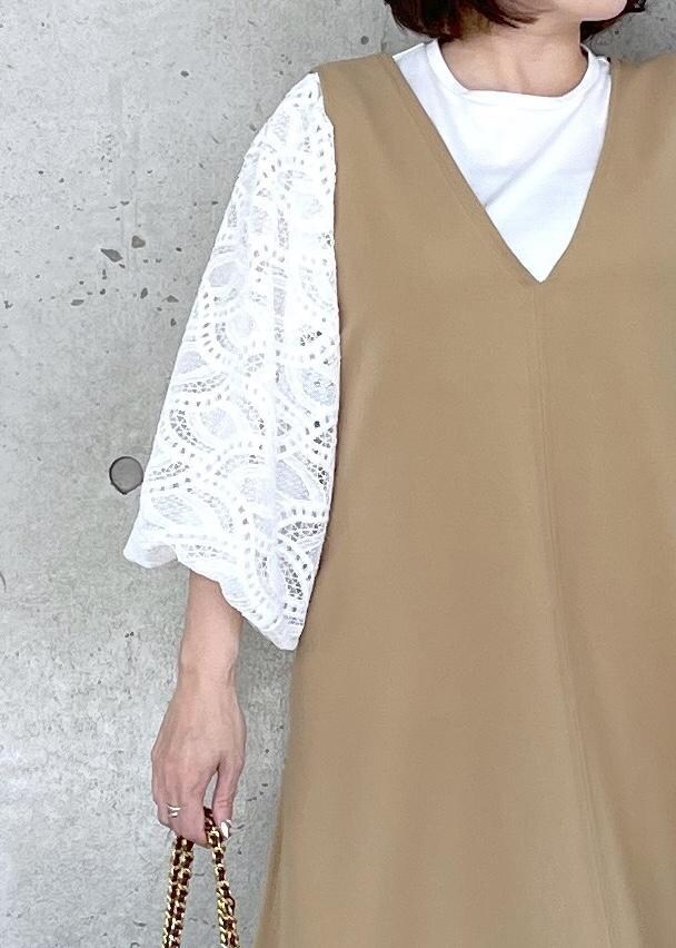 ホワイト系のブーツ、レッド系のハンドバッグ、ベージュ系のジャンパースカートを着用したレディースの秋コーディネートの8枚目の写真