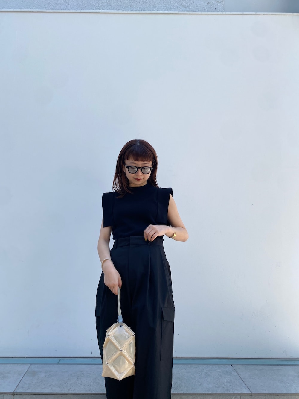 ブラック系のニット/セーター、ブラック系のカーゴパンツ、ブラック系のその他シューズを着用したレディースの春コーディネートの3枚目の写真