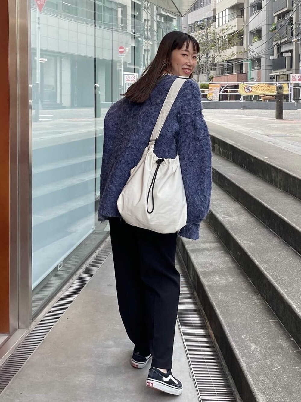 ブルー系のニット/セーター、ホワイト系のショルダーバッグを着用したレディースの秋コーディネートの3枚目の写真