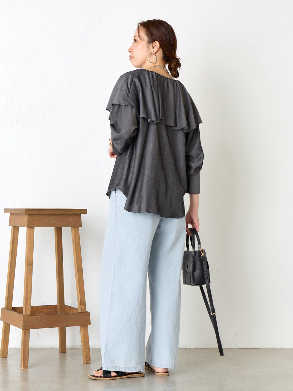 ブラック系のシャツ/ブラウス、ブラック系のトートバッグ、ブルー系のデニムパンツを着用したレディースの夏コーディネートの3枚目の写真