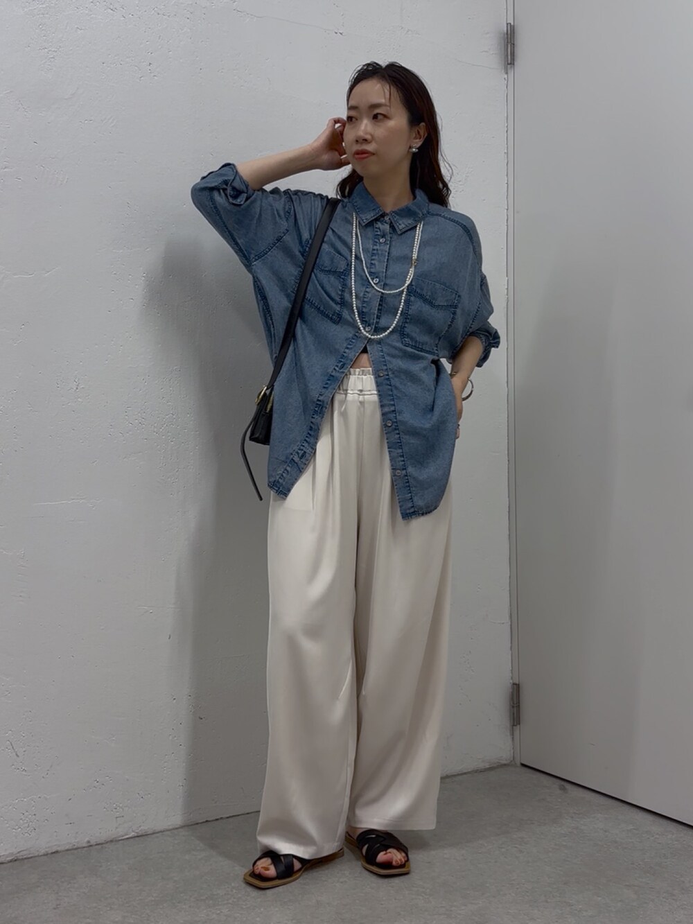 ブルー系のシャツ/ブラウス、ホワイト系のその他パンツ、ブラック系のショルダーバッグを着用したレディースの春コーディネートの2枚目の写真