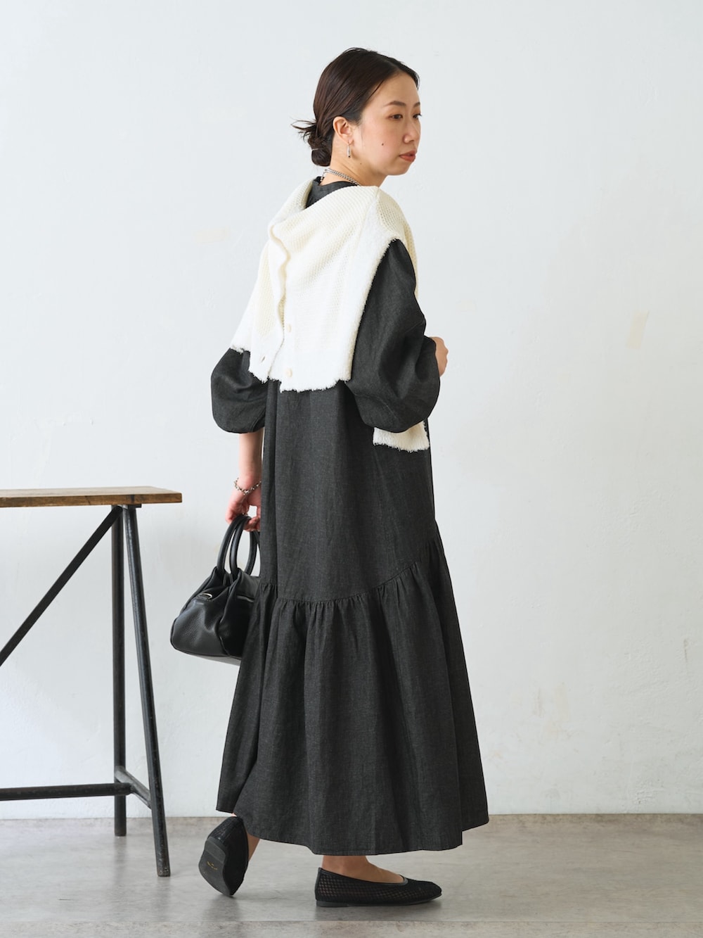 ホワイト系のカーディガン/ボレロ、ブラック系のワンピース、ブラック系のトートバッグを着用したレディースの冬コーディネートの2枚目の写真