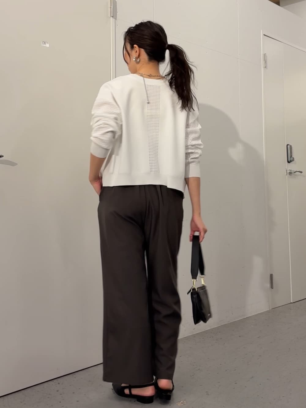 ホワイト系のカーディガン/ボレロ、ブラック系のトートバッグ、グレー系のワンピースを着用したレディースの冬コーディネートの2枚目の写真