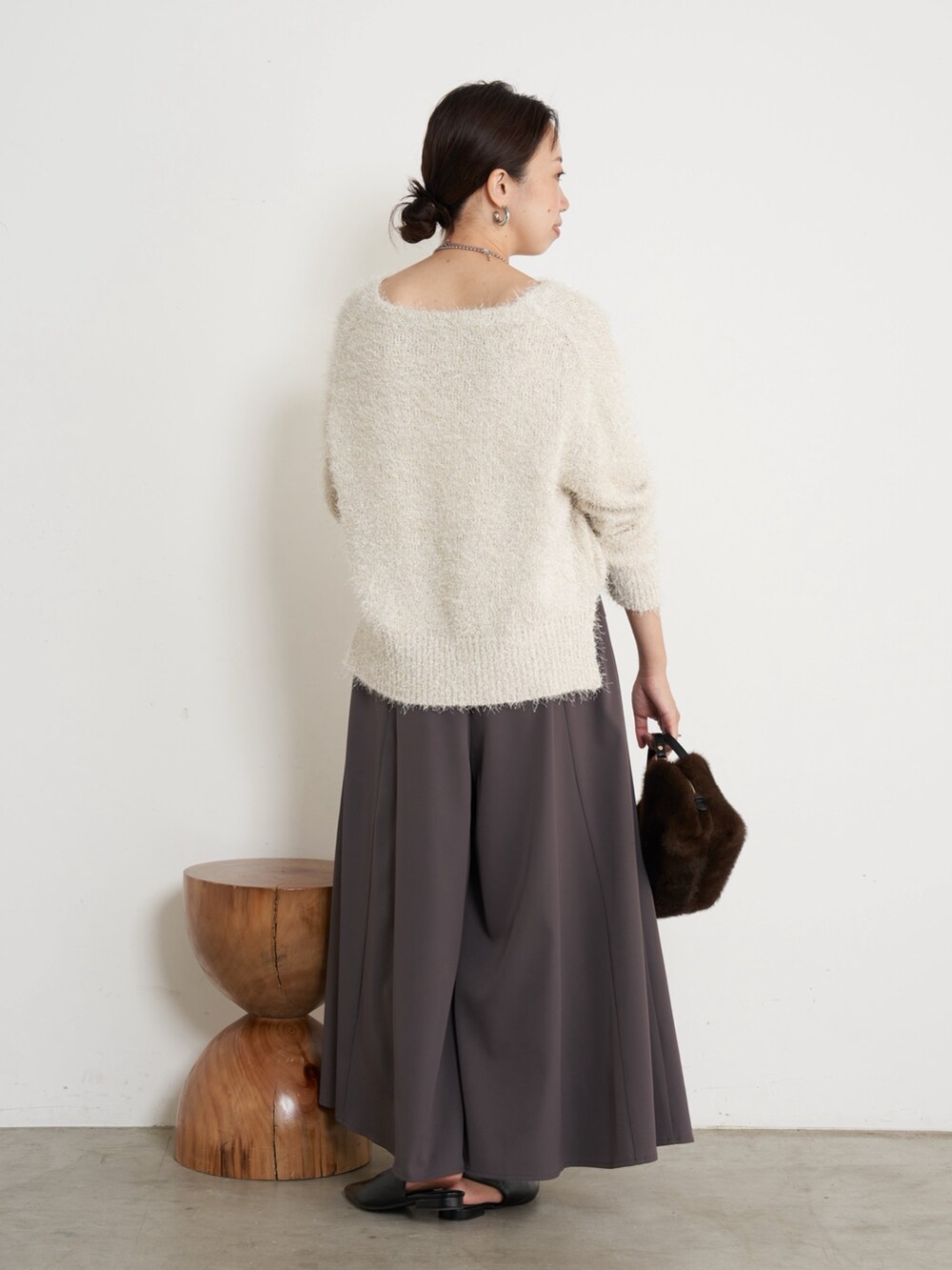 ホワイト系のニット/セーター、ブラウン系のその他パンツ、ブラウン系のトートバッグを着用したレディースの秋コーディネートの2枚目の写真