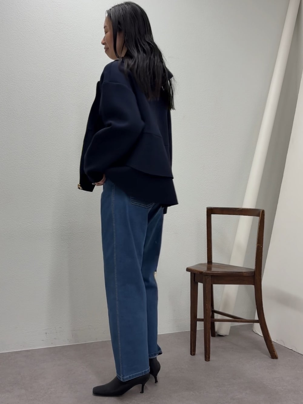 ブルー系のデニムパンツ、ブルー系のパーカー、ブラック系のトートバッグを着用したレディースの冬コーディネートの2枚目の写真