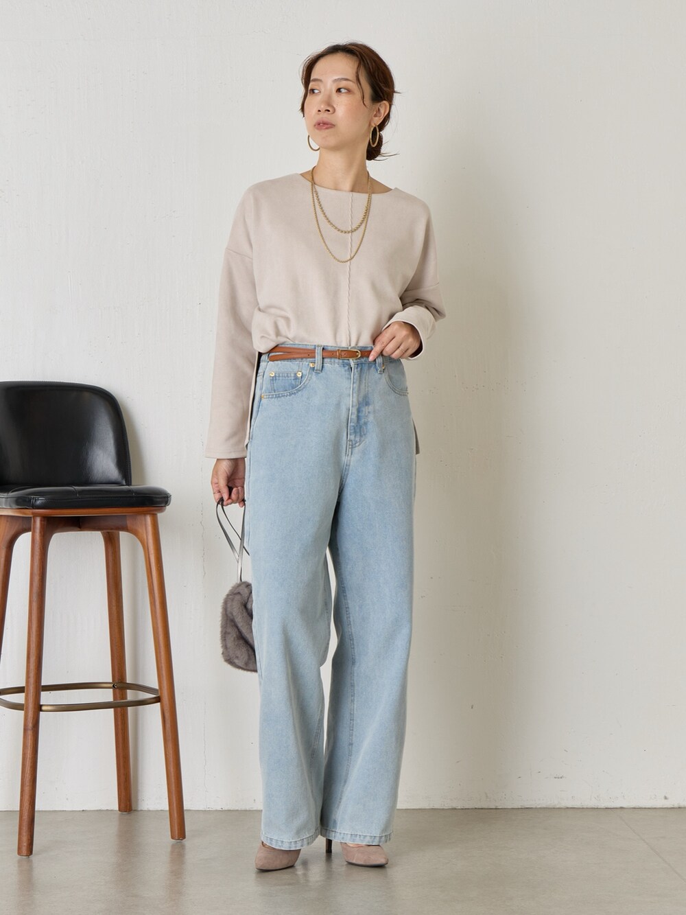 グレー系のTシャツ/カットソー、ブルー系のデニムパンツ、ブラック系のトートバッグを着用したレディースの秋コーディネートの3枚目の写真