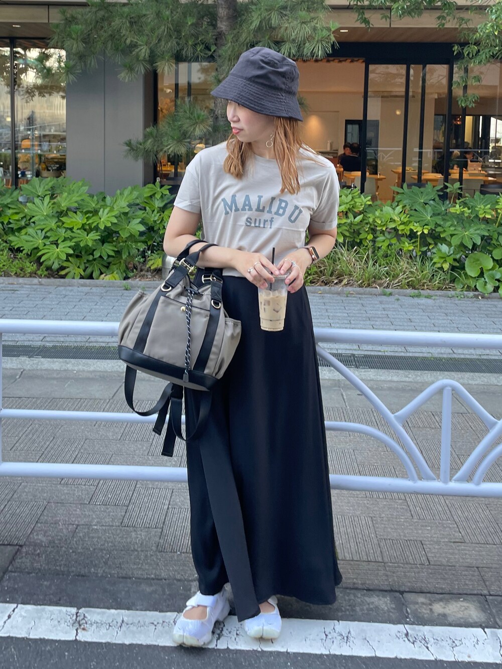 グレー系のTシャツ/カットソー、ブラック系のスカート、グレー系のバックパック/リュックを着用したレディースの夏コーディネートの2枚目の写真