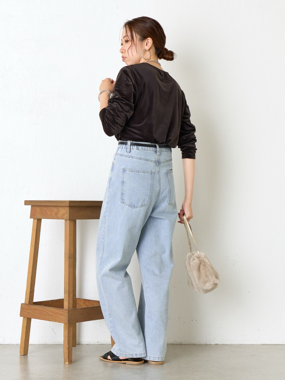 ブラウン系のトートバッグ、ブラック系のサンダル、ブルー系のデニムパンツを着用したレディースの夏コーディネートの2枚目の写真