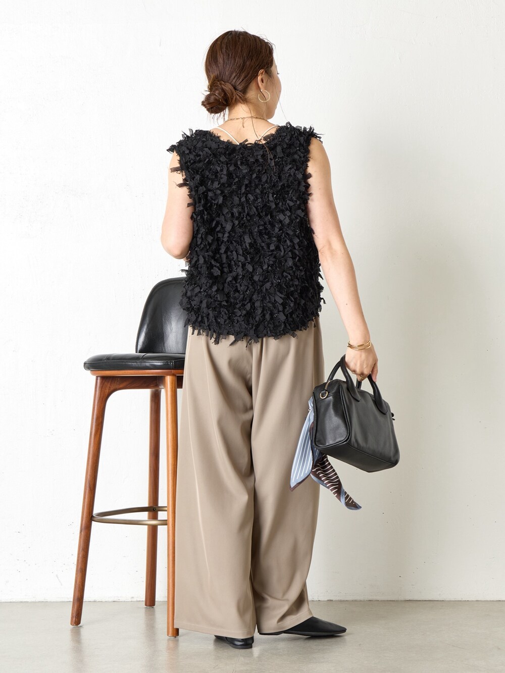 ブラック系のベスト、ブラック系のショルダーバッグ、グレー系のその他パンツを着用したレディースの夏コーディネートの3枚目の写真