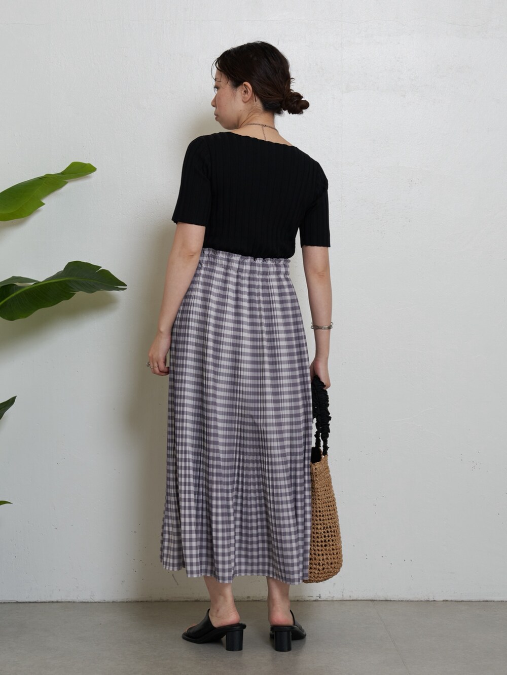 ブラック系のニット/セーター、グレー系のスカート、ブラック系のトートバッグを着用したレディースの春コーディネートの3枚目の写真