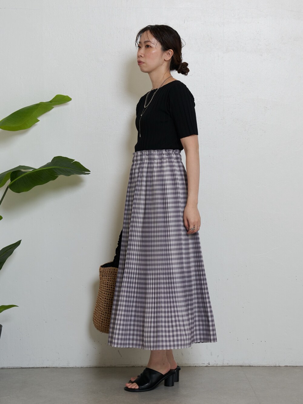 ブラック系のニット/セーター、グレー系のスカート、ブラック系のトートバッグを着用したレディースの春コーディネートの2枚目の写真