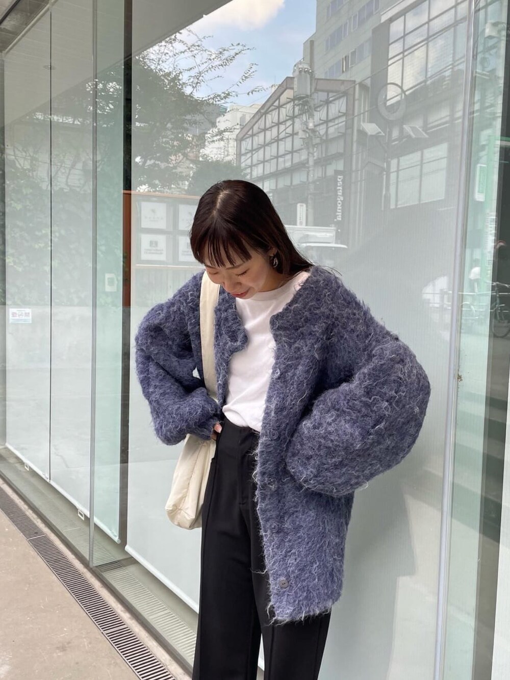 ブルー系のニット/セーター、ホワイト系のショルダーバッグを着用したレディースの秋コーディネートの4枚目の写真