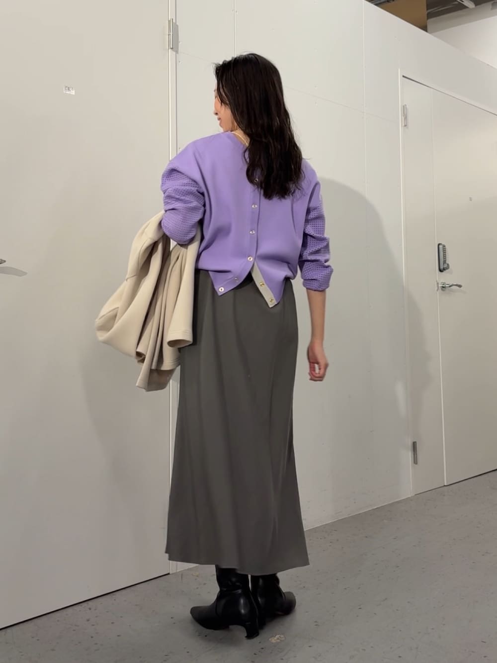 ブラック系のトートバッグ、パープル系のカーディガン/ボレロ、グレー系のスカートを着用したレディースの冬コーディネートの2枚目の写真