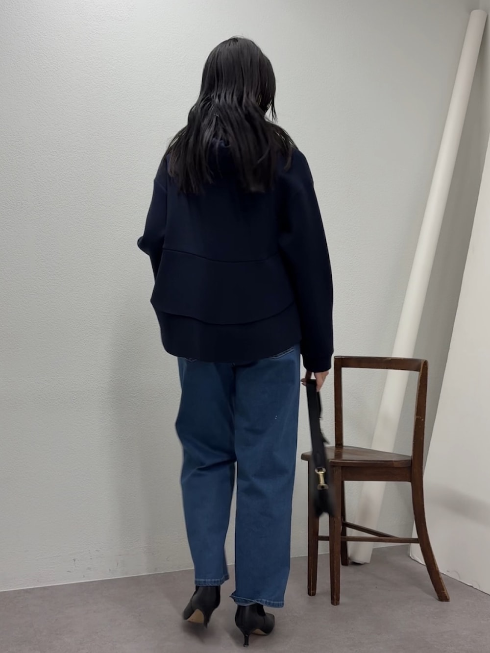 ブルー系のデニムパンツ、ブルー系のパーカー、ブラック系のトートバッグを着用したレディースの冬コーディネートの3枚目の写真