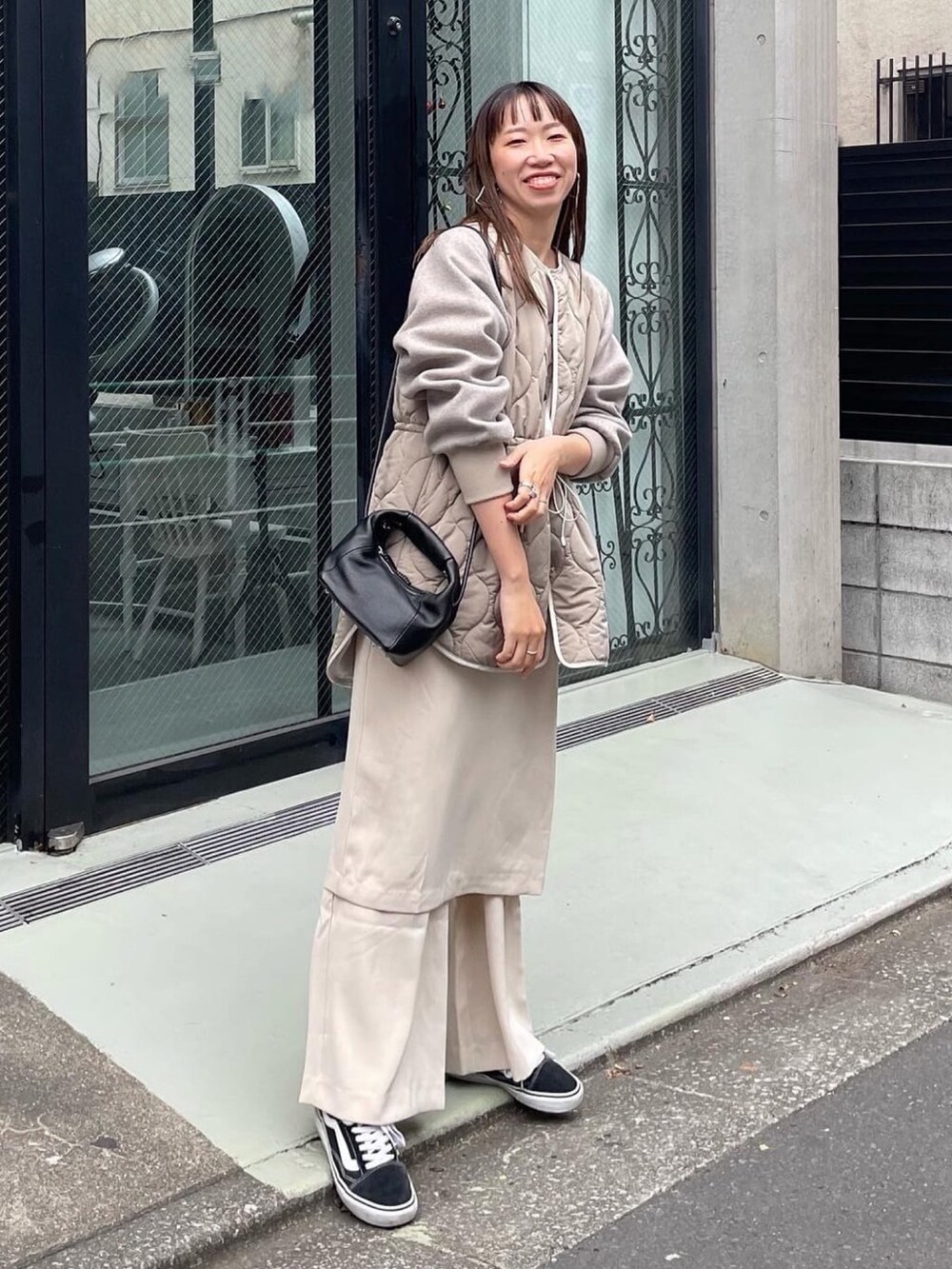 グレー系のその他アウター、ブラック系のショルダーバッグを着用したレディースの秋コーディネートの2枚目の写真