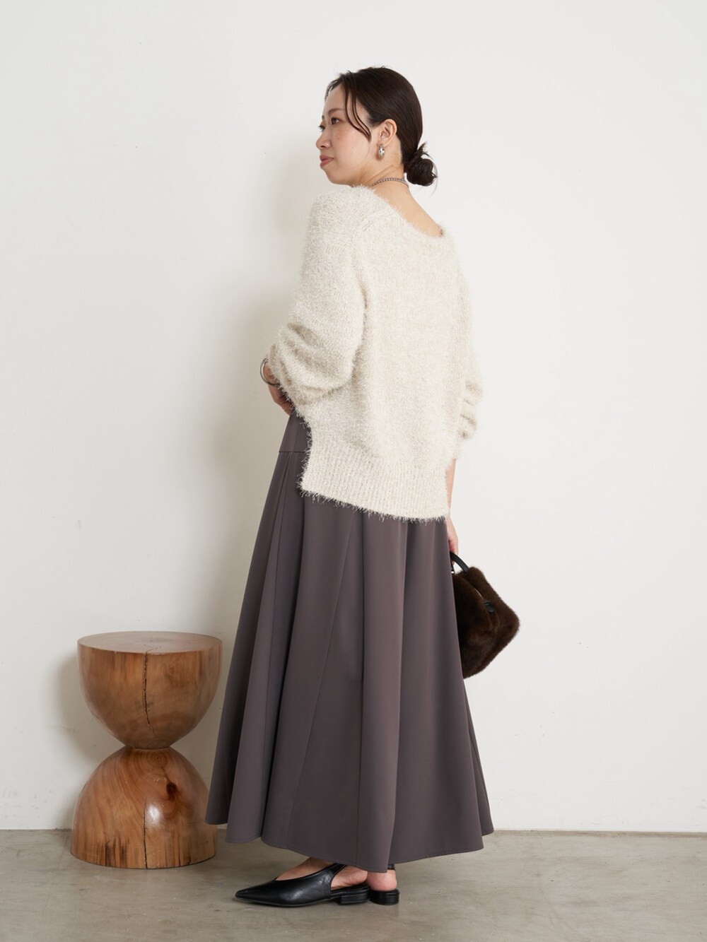 ホワイト系のニット/セーター、ブラウン系のその他パンツ、ブラウン系のトートバッグを着用したレディースの秋コーディネートの3枚目の写真