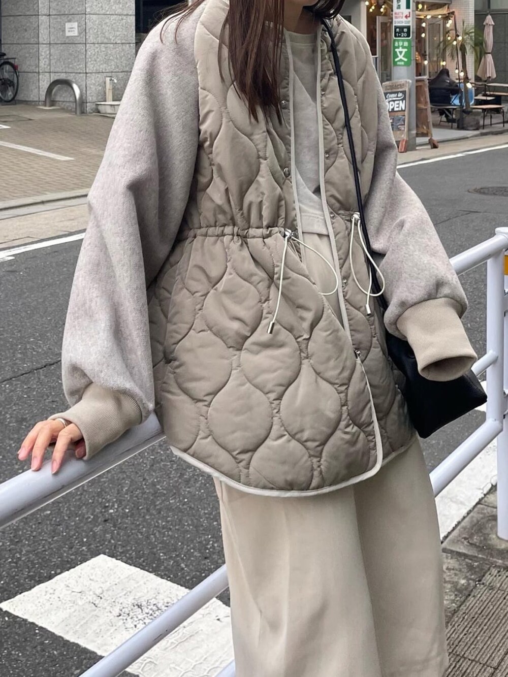 グレー系のその他アウター、ブラック系のショルダーバッグを着用したレディースの秋コーディネートの4枚目の写真