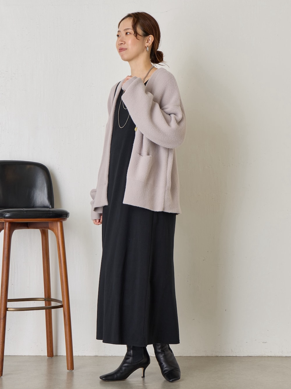 グレー系のカーディガン/ボレロ、ブラック系のトートバッグ、ホワイト系のワンピースを着用したレディースの秋コーディネートの2枚目の写真